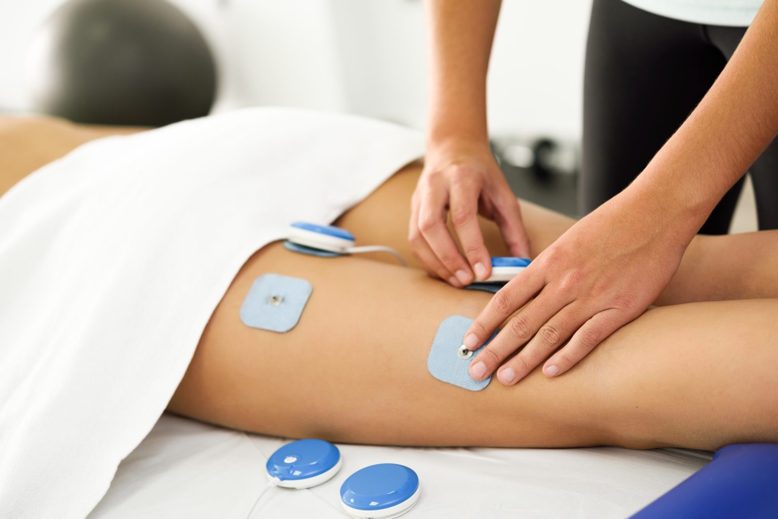 physiotherapist-applying-electro-stimulation-in-physical-therapy-to-a-young-woman-leg-1-1536x1025 Tens